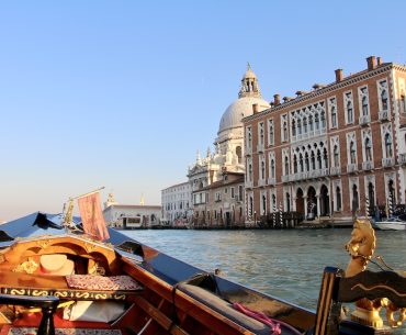 A bord d'une gondole à Venise sur le Grand Canal, sous un beau ciel bleu.